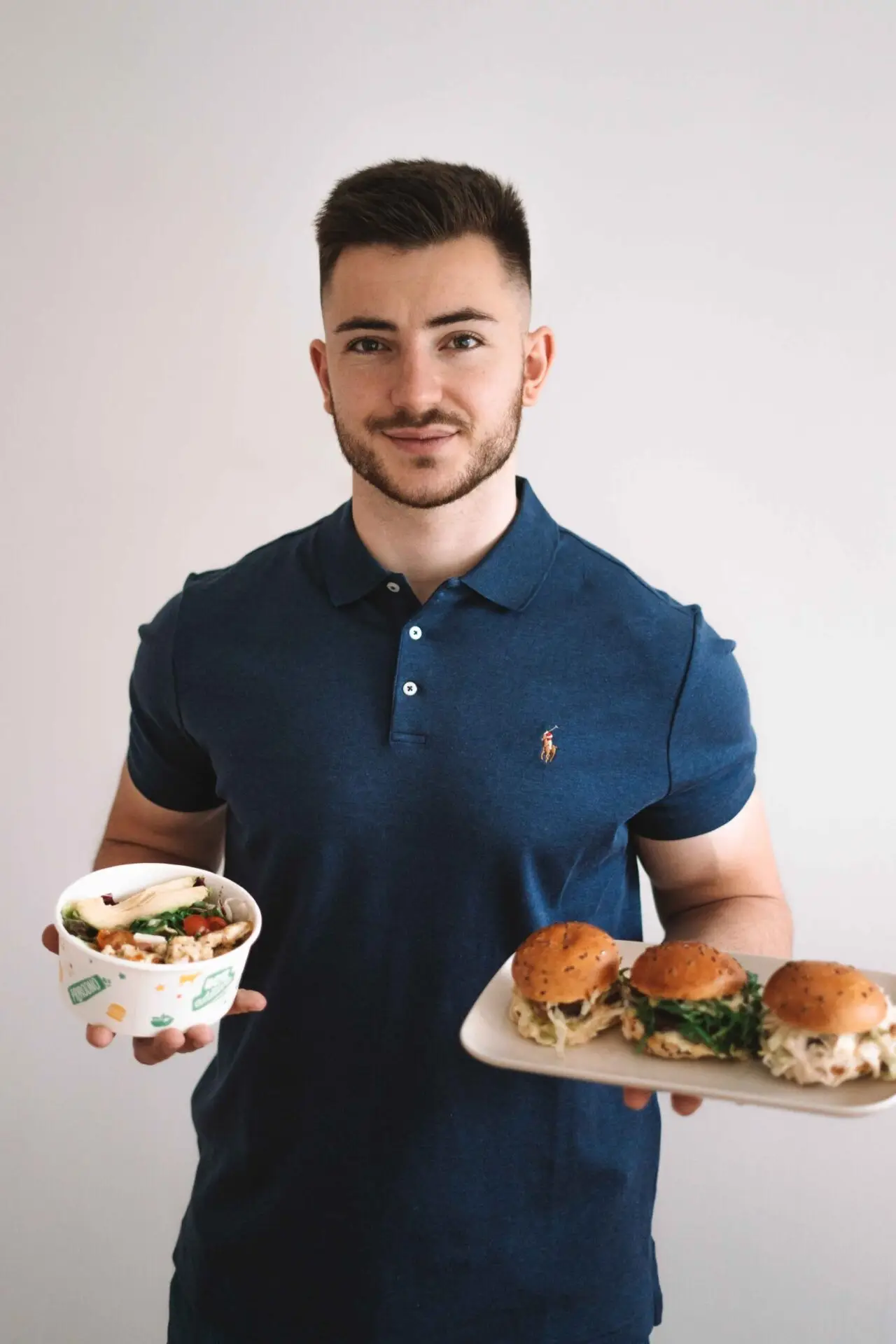 Osobni Trener Antonio Perić jede hranu bogatu proteinima u cilju mrsavljenja. U jednoj ruci ima salatu, a u drugoj hamburgere sto simbolizira fleksibilno jedenje.